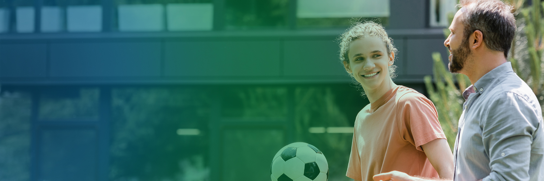 son holding soccer ball with dad
